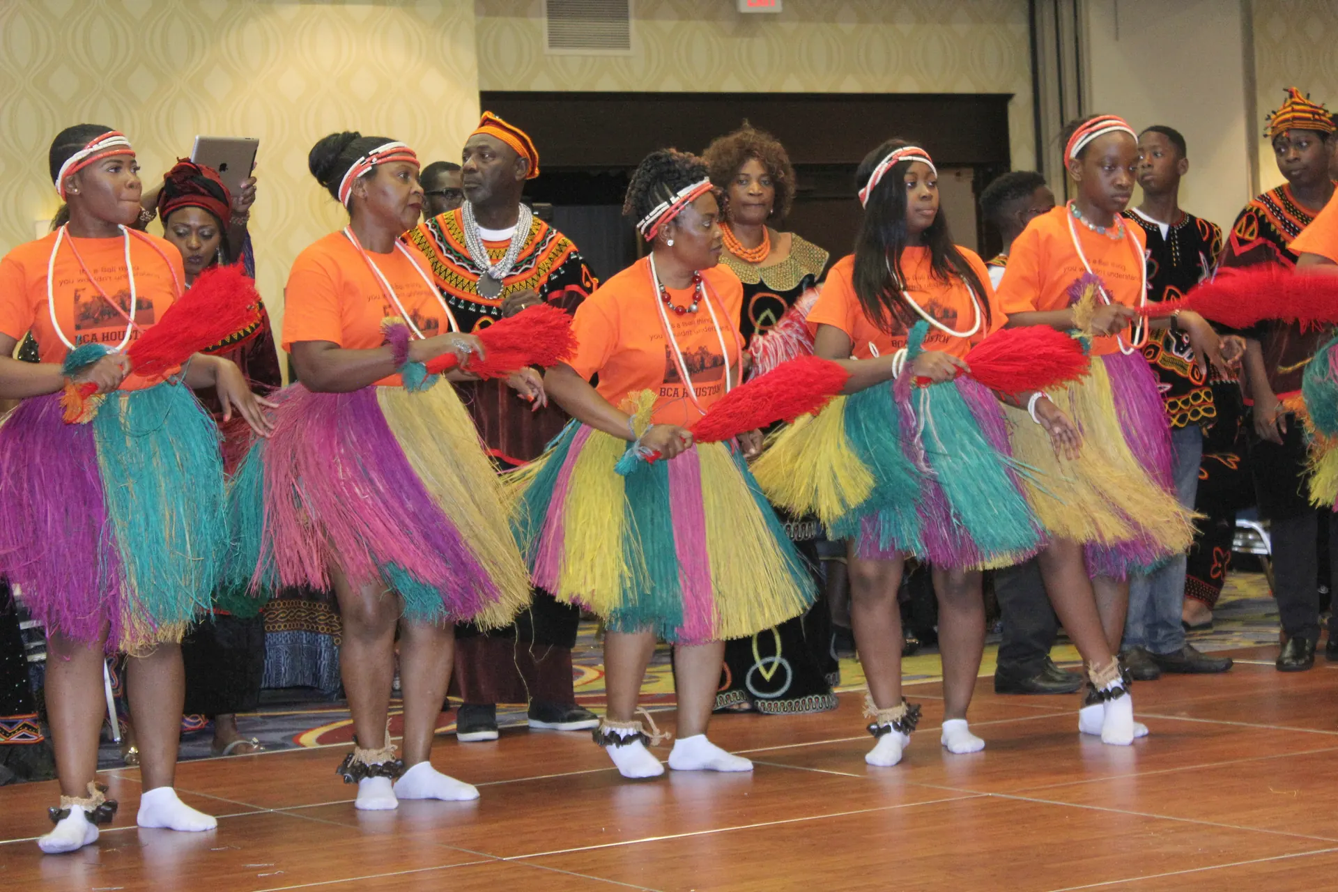 Young women performing a traditional dance in colorful raffia skirts